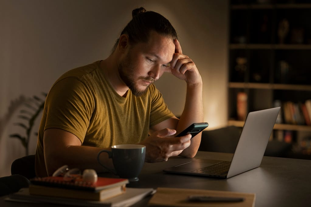 Adult person working late at home on a computer, needing ideas on how to motivate employees.