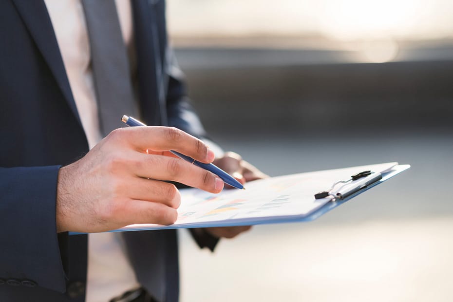 Close-up of a businessman checking a clipboard.